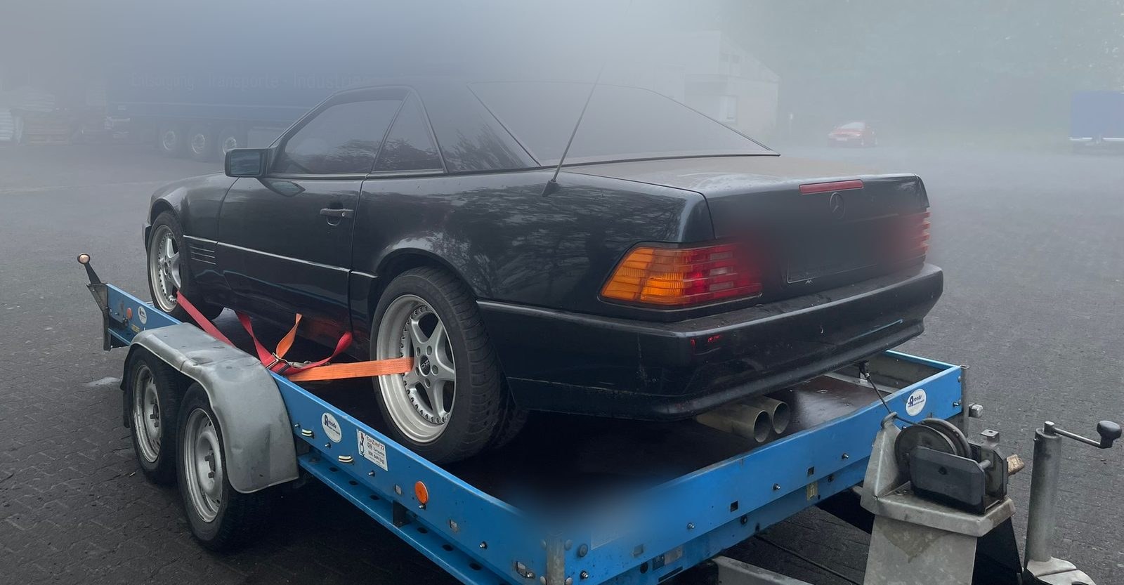 Mercedes SL auf einem Autoanhänger, aufgenommen im Morgennebel