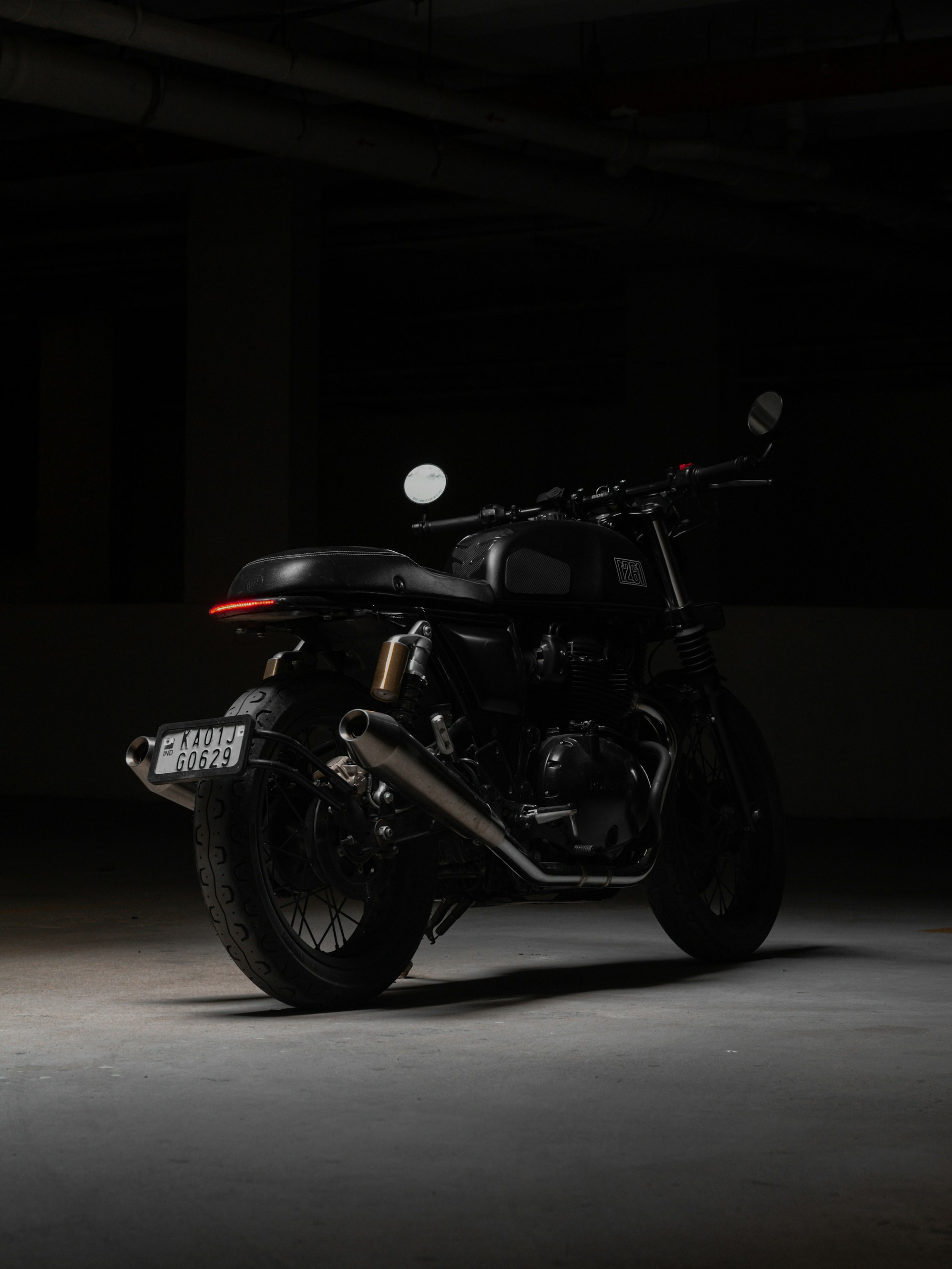 Motorrad in einer dunklen Halle, seitlich angestrahlt