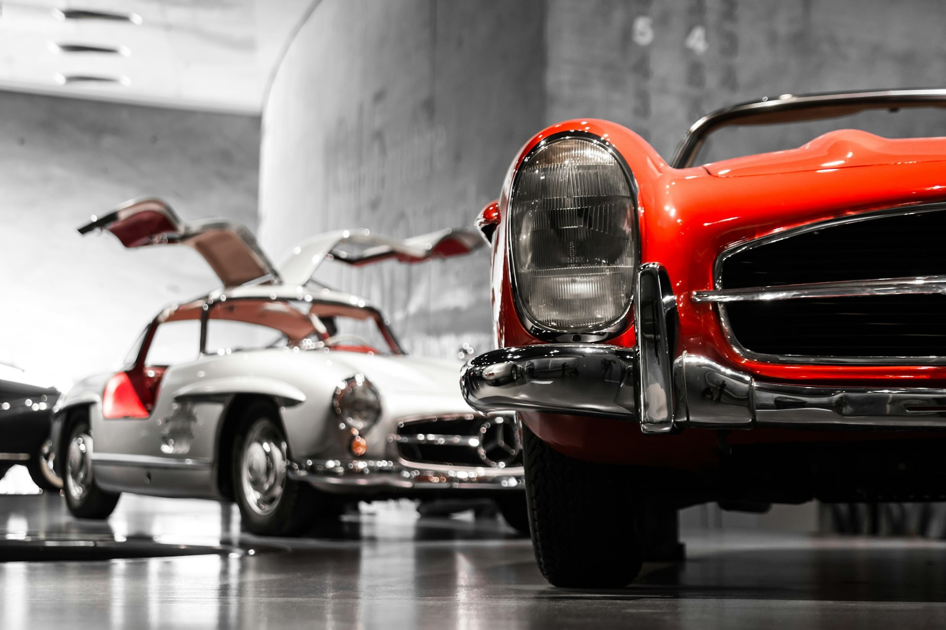 Zwei Oldtimer in einer Ausstellungshalle